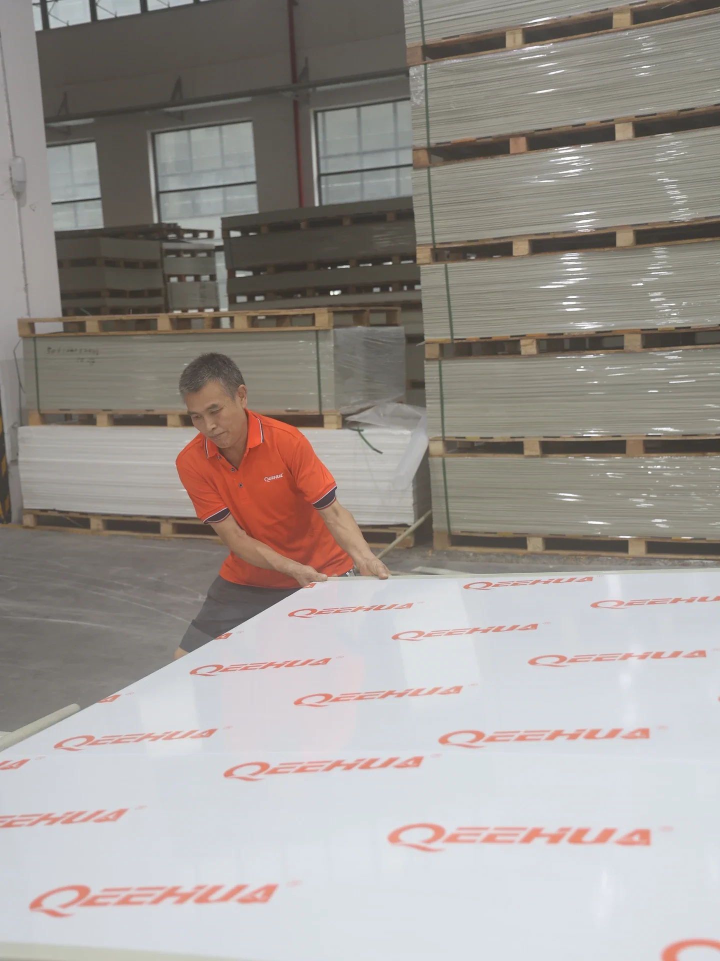 QEEHUA operator handling a PP sheet in the factory warehouse